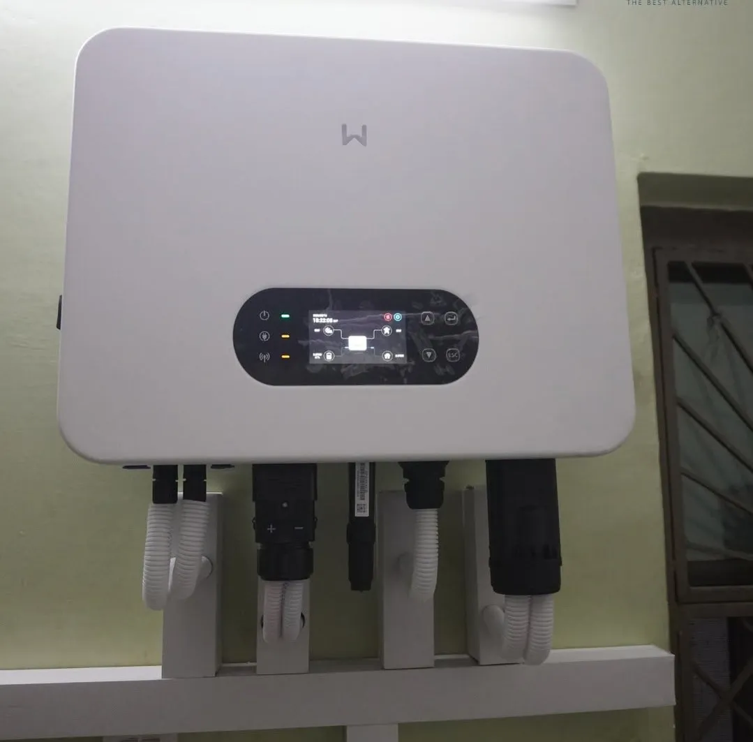Wall-mounted 10 kW hybrid inverter with a colour power-flow display and conduit for PV, battery, and grid connections